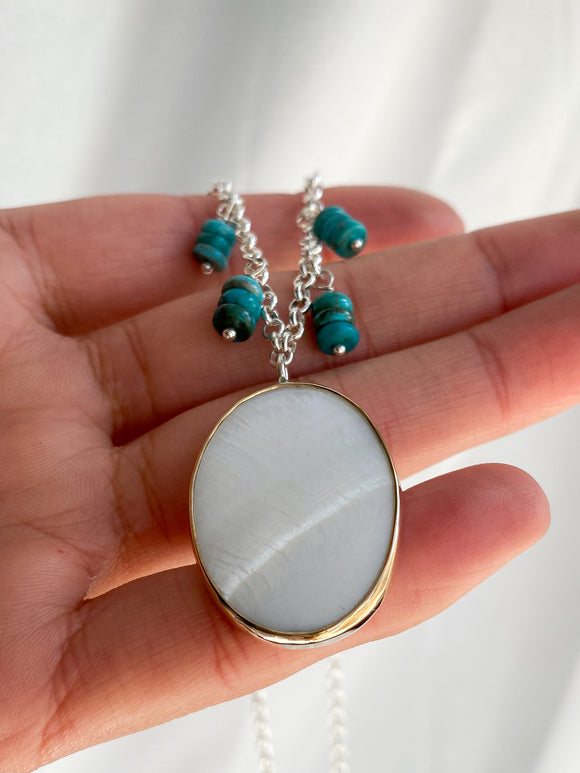 sterling silver pendant with mother of pearl set in 14k yellow gold bezel and finished with turquoise beads on the necklace chain kaivi jewelry woman wearing pendant